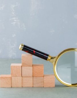 searching-business-concept-with-wooden-blocks-magnifying-glass-side-view_176474-10438